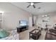 Open living room showcasing a TV, ceiling fan, and adjacent dining area at 1357 Venezia Ct # 402, Davenport, FL 33896