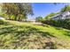 Grassy backyard featuring mature trees and distant view of the home at 1400 Tedford St, Eustis, FL 32726