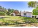 Beautiful exterior view showcasing lush lawn, mature trees and blue shutters on the windows at 1400 Tedford St, Eustis, FL 32726