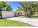 Lovely front exterior view showcasing mature trees, lush lawn and long driveway to a two-car garage at 1400 Tedford St, Eustis, FL 32726