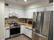 Well-lit kitchen featuring white cabinets and stainless steel appliances at 1400 Tedford St, Eustis, FL 32726