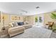 Bright living room with plush sectional, ceiling fan, and access to patio at 1400 Tedford St, Eustis, FL 32726