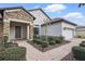 Charming home featuring a stone facade, manicured landscaping, and a welcoming brick walkway leading to the front door at 1407 Deuce Cir, Davenport, FL 33896