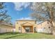 View of the home's exterior with a covered patio, sliding glass door, and well-maintained lawn at 14806 Del Morrow Way, Orlando, FL 32824