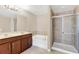 Bathroom featuring double sinks, a separate tub, and a walk-in shower with glass door at 14806 Del Morrow Way, Orlando, FL 32824