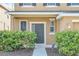 The home's entry features manicured landscaping and a visible security system at 14806 Del Morrow Way, Orlando, FL 32824