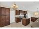 Open kitchen with granite countertops, stainless steel appliances and stylish chandelier lighting at 14806 Del Morrow Way, Orlando, FL 32824