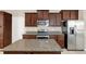 This kitchen features granite countertops, stainless steel appliances, and dark wood cabinets at 14806 Del Morrow Way, Orlando, FL 32824