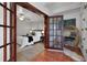 Cozy bedroom with french doors leading to a relaxing sunroom with a stylish chair and greenery at 151 N Orlando Ave # 229, Winter Park, FL 32789