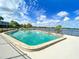 Beautiful community pool overlooking the lake with lounge chairs and a clear blue sky at 151 N Orlando Ave # 229, Winter Park, FL 32789