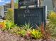 The Lake Killarney Condominiums sign is surrounded by colorful plants, adding a touch of nature to the entrance at 151 N Orlando Ave # 229, Winter Park, FL 32789