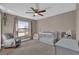 Relaxing bedroom with a ceiling fan, rocking chair, and a large window at 1585 Randolph St, Deltona, FL 32725