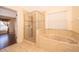 Tiled bathroom showcasing a glass-enclosed shower and soaking tub with vanity area at 2260 The Oaks Blvd, Kissimmee, FL 34746