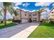 Charming two-story home with a well-manicured front lawn, mature trees, and a driveway leading to a two-car garage at 2260 The Oaks Blvd, Kissimmee, FL 34746