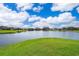 Serene lake view surrounded by lush green landscape, creating a peaceful and picturesque setting at 2260 The Oaks Blvd, Kissimmee, FL 34746