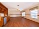 Spacious living room featuring wood floors, built in bar with cabinets and mini fridge, ceiling fan, and natural light at 2260 The Oaks Blvd, Kissimmee, FL 34746