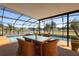 Screened-in patio with pool, lake view, and outdoor dining area at 2260 The Oaks Blvd, Kissimmee, FL 34746