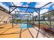 Screened-in pool area overlooking tranquil lake with palm trees and plenty of space for outdoor enjoyment at 2260 The Oaks Blvd, Kissimmee, FL 34746