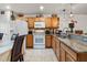 Well-equipped kitchen with granite counters, wooden cabinets, and modern white appliances, offering functionality and style at 2478 Pillar Coral Dr # S, Orlando, FL 32808