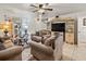 Cozy living room featuring plush sofas, a ceiling fan, and a decorative entertainment center with display cabinets at 2478 Pillar Coral Dr # S, Orlando, FL 32808