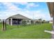 Spacious backyard with lush green grass, screened-in lanai, and secure black metal fence at 2741 Southland St, St Cloud, FL 34772