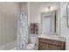 Full bathroom featuring shower with decorative curtain, granite-topped vanity, and neutral tile at 2741 Southland St, St Cloud, FL 34772