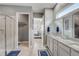 Bright bathroom features double sink vanity, granite countertop, and tiled walk-in shower at 2741 Southland St, St Cloud, FL 34772