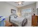 Comfortable bedroom features a metal bed frame, ceiling fan, and bright natural light at 2741 Southland St, St Cloud, FL 34772