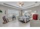 Serene bedroom features tray ceiling, neutral walls, ceiling fan and a rocking chair for cozy relaxation at 2741 Southland St, St Cloud, FL 34772