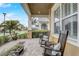 Covered front porch featuring rocking chairs and decorative stone pillars and lush landscaping at 2741 Southland St, St Cloud, FL 34772