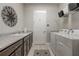 Well-lit laundry room features granite counters, utility sink, shelving and white washer/dryer at 2741 Southland St, St Cloud, FL 34772