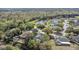 Aerial view of home with solar panels and screened-in pool nestled in a quiet, wooded neighborhood at 2856 Broward Ct, Oviedo, FL 32765