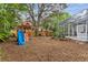 Wooden playset with swings and slide in a mulch-covered backyard with the screened pool in the background at 2856 Broward Ct, Oviedo, FL 32765