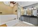 Bright bathroom with a large tub, separate shower and double sink vanity with modern lighting fixtures at 2856 Broward Ct, Oviedo, FL 32765