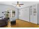 Cozy bedroom with a large window, ceiling fan, and a convenient Murphy bed and storage cabinets at 2856 Broward Ct, Oviedo, FL 32765
