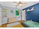 A bedroom featuring a ceiling fan, light wood flooring, and blue accent wall at 2856 Broward Ct, Oviedo, FL 32765