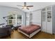 Comfortable bedroom with wood floors, large window, and a practical Murphy bed with shelving at 2856 Broward Ct, Oviedo, FL 32765