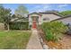 Welcoming single-story home showcasing a neat lawn, mature trees, and a vibrant red front door at 2856 Broward Ct, Oviedo, FL 32765