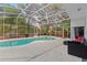 A screened-in pool area featuring a pool, spa, and outdoor seating at 2856 Broward Ct, Oviedo, FL 32765