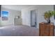 Upstairs landing area showcasing a neutral color scheme, window, and decorative wooden cabinet at 3017 Moulin Rd, Davenport, FL 33837