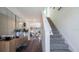 Inviting hallway with hardwood floors leading to a carpeted staircase and a glimpse of the living room at 3017 Moulin Rd, Davenport, FL 33837