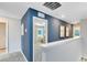 Upstairs hallway featuring blue accent wall, neutral carpet, and natural light from nearby windows at 3199 Emerald Acres Ln, Sanford, FL 32771