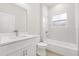 Bright bathroom featuring a white vanity and shower-tub combo with tiled walls at 3995 Sw 151 Street, Ocala, FL 34473