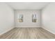 Bright bedroom featuring two windows and laminate wood flooring providing a neutral and inviting space at 3995 Sw 151 Street, Ocala, FL 34473