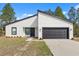 Newly built home featuring white exterior with a modern black-trimmed garage and windows at 3995 Sw 151 Street, Ocala, FL 34473