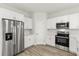 Cozy kitchen with stainless steel appliances, white cabinets, and hardwood style floors at 3995 Sw 151 Street, Ocala, FL 34473