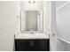 Bathroom with a marble-look countertop, black cabinets, and a large mirror at 411 Lily Ln, Davenport, FL 33837