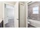 Bathroom featuring a tub with tiled walls, and access to a bedroom and closet at 411 Lily Ln, Davenport, FL 33837