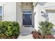 Inviting front entry with a dark blue door, manicured landscaping, and decorative lantern at 411 Lily Ln, Davenport, FL 33837