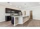 Modern kitchen with stainless steel appliances, dark cabinetry, granite counters, and pendant lighting at 411 Lily Ln, Davenport, FL 33837